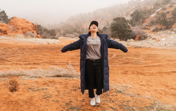 Woman with arms outstretched wearing Hemplucid shirt in desert