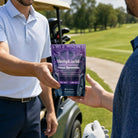 A middle-aged man handing a bag of HempLucid Focus Gummies 30CT bag to his friend on a golf course, the cart visible in the background.