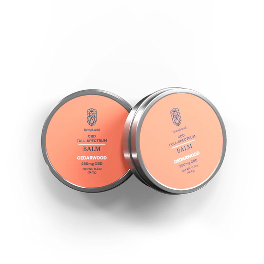 Two tins of HempLucid CBD Full-Spectrum Balm with Cedarwood, each containing 250mg CBD, displayed with salmon-colored labels.